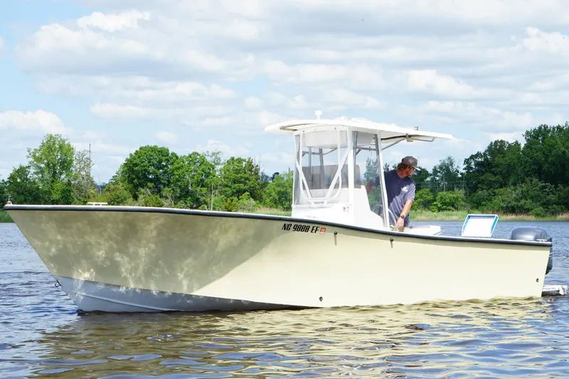 Slide: The Image of 1993 KenCraft CHALLENGER 250CC boat on a calm lake with a person onboard. - 5