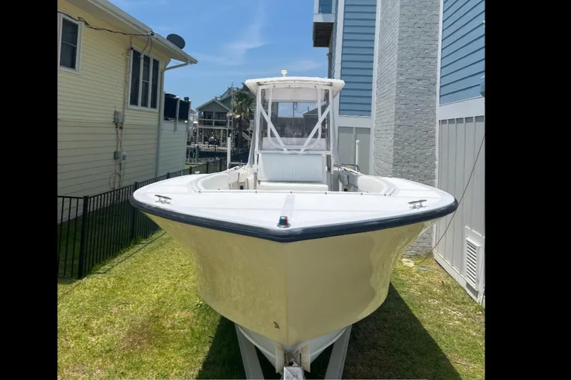 Slide: The Image of 1993 KenCraft Challenger 250CC boat parked between houses on grass. - 8
