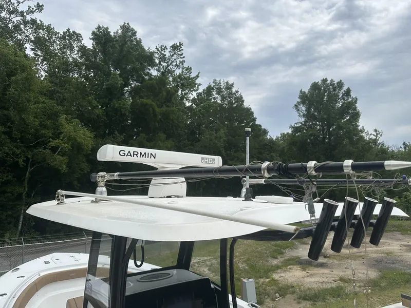 Slide: The Image of 2020 Sea Hunt Gamefish 30 boat with Garmin radar and rod holders, surrounded by trees. - 33