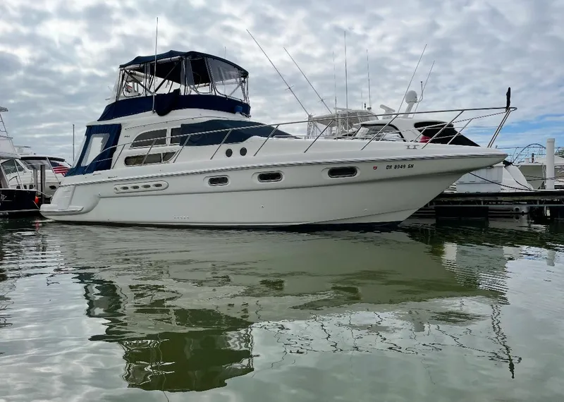 Slide: The Image of 2000 Sealine F44 yacht docked in a marina, reflecting on calm water. - 0