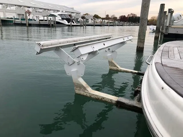 Slide: The Image of Boat lift mechanism beside a Sealine F44 yacht, 2000 model, at a marina dock. - 2