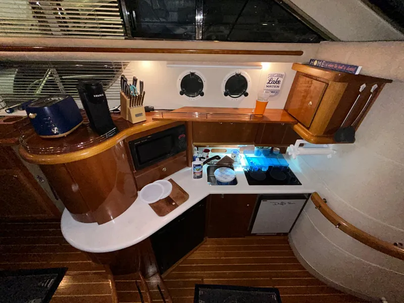Slide: The Image of Interior of a 2000 Sealine F44 yacht kitchen with wooden cabinetry and modern appliances. - 23
