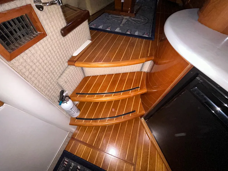 Slide: The Image of Interior of 2000 Sealine F44 yacht with wooden steps and fire extinguisher. - 24