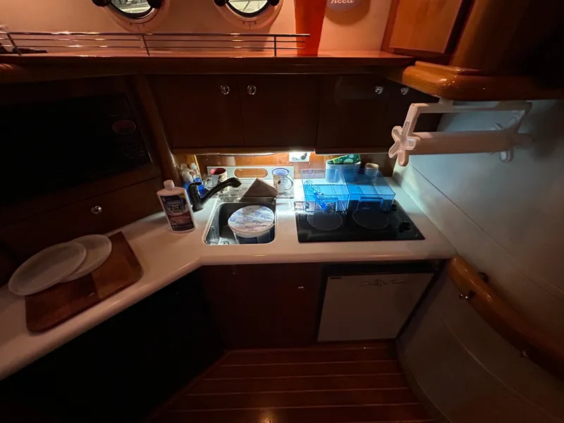Slide: The Image of Sealine F44 2000 yacht kitchen with sink, stove, and wooden cabinetry. - 25