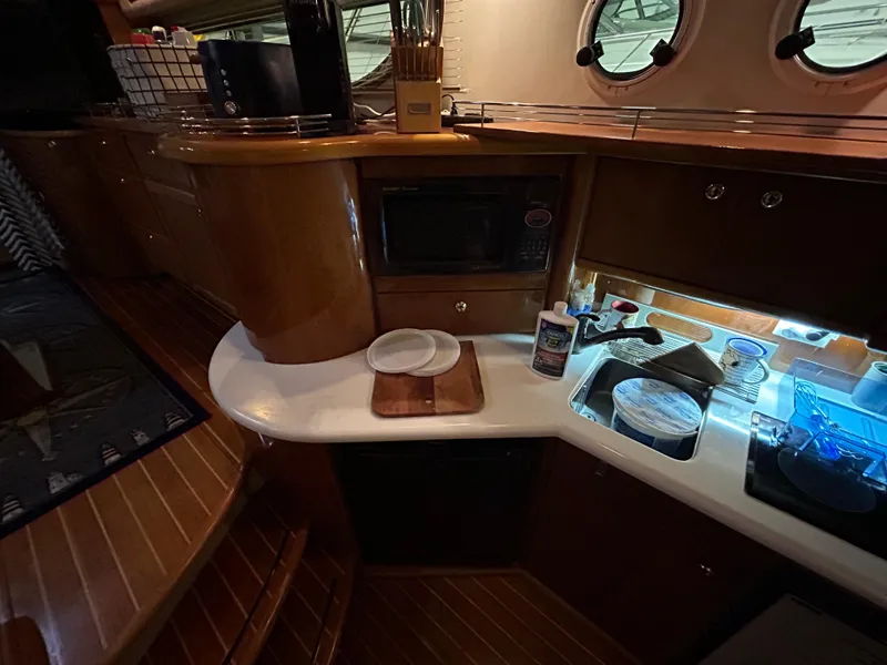 Slide: The Image of Interior of 2000 Sealine F44 yacht kitchen with wooden cabinetry and modern appliances. - 26