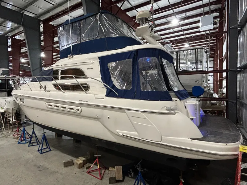 Slide: The Image of 2000 Sealine F44 yacht in storage, featuring blue canopy and sleek design. - 5