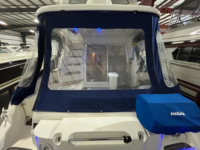 Slide: The Image of Sealine F44 yacht, 2000 model, with blue canopy and covered seating area in a marina. - 8