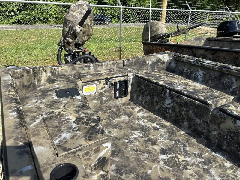 Slide: The Image of Camouflage-patterned Excel Viper F4 1751 boat, 2025 model, with outboard motor, parked by a fence. - 10
