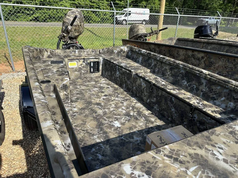 Slide: The Image of 2025 Excel Viper F4 1751 boat with camouflage design, parked outdoors near a fence. - 5