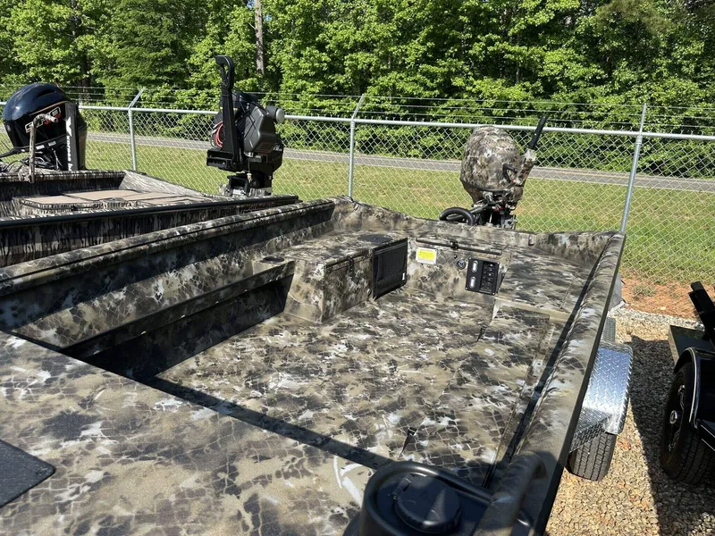 Slide: The Image of 2025 Excel Viper F4 1751 boat with camouflage design, parked outdoors near a fence. - 5