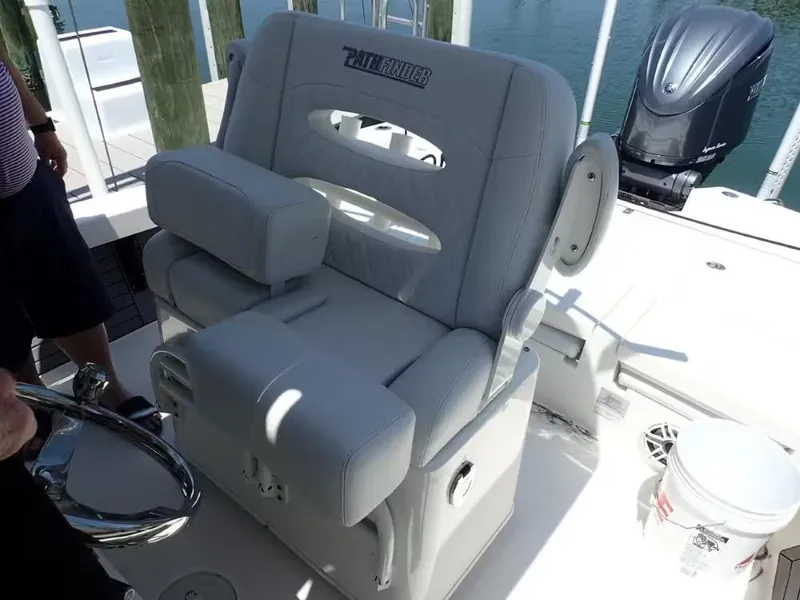 Slide: The Image of 2024 Pathfinder 2600 TRS boat seat with steering wheel and engine in background. - 5