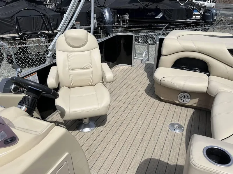 Slide: The Image of 2018 Sylvan Mirage 8522 Cruise Port interior with beige seating and steering wheel. - 8