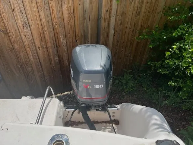 Slide: The Image of 1997 Grady-White F-26 Tigercat with Yamaha V6 150 outboard motor, near wooden fence. - 12