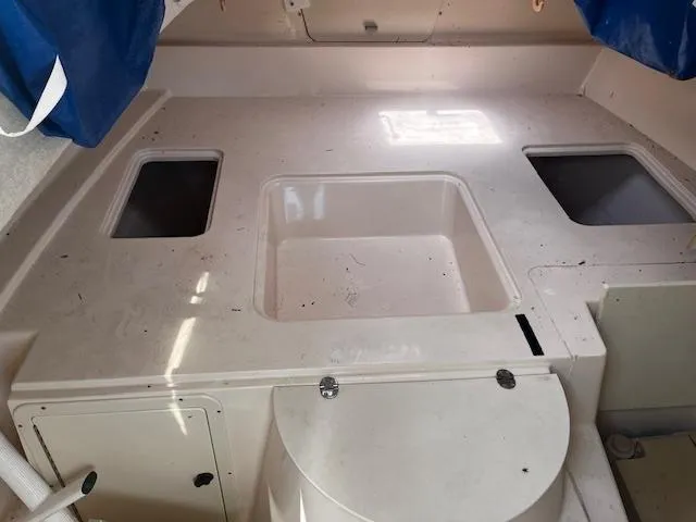 Slide: The Image of 1997 Grady-White F-26 Tigercat interior with storage compartments and seating area. - 7