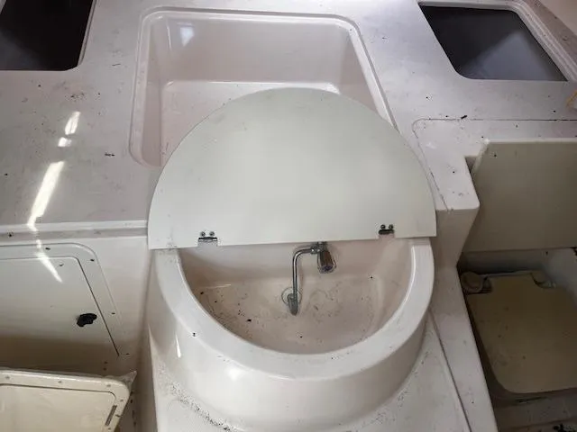 Slide: The Image of 1997 Grady-White F-26 Tigercat boat sink with closed lid and faucet. - 8