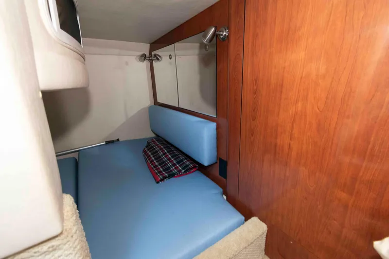 Slide: The Image of 2007 Sea Ray 280 Sundancer cabin interior with blue seating and wood paneling. - 10