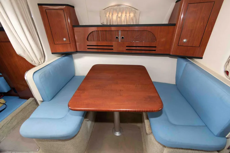 Slide: The Image of Interior of 2007 Sea Ray 280 Sundancer with wooden table and blue seating. - 8