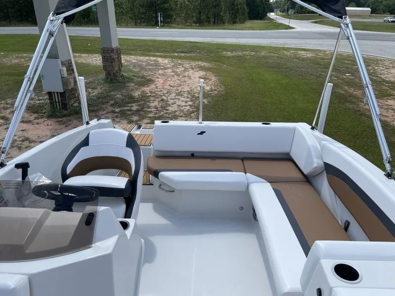 Slide: The Image of 2025 Starcraft SVX-171 boat interior with white and brown seating, parked outdoors. - 11