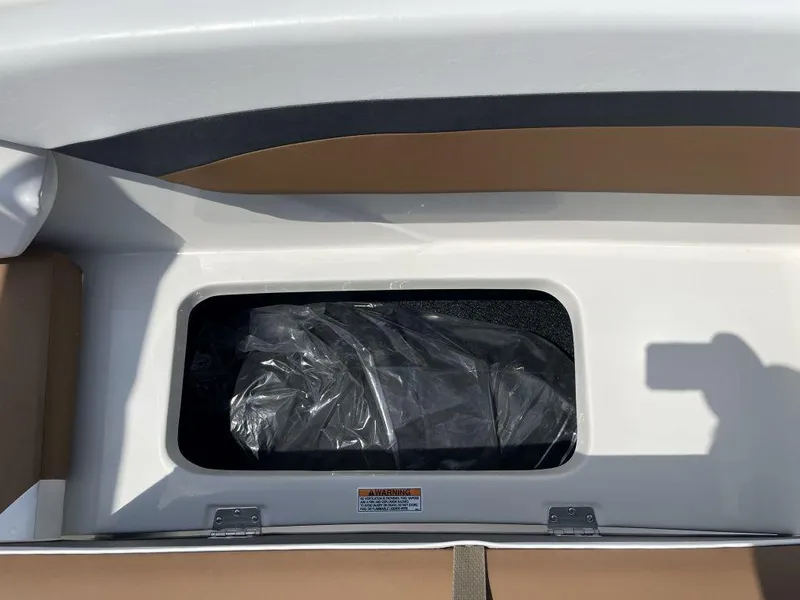 Slide: The Image of Storage compartment of 2025 Starcraft SVX-171 boat, featuring brown and white interior. - 17