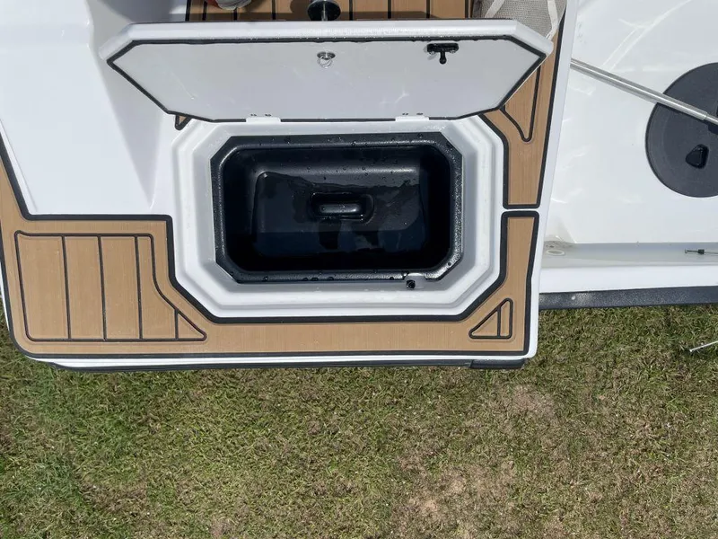 Slide: The Image of Open storage compartment on 2025 Starcraft SVX-171 boat, featuring wood-patterned deck. - 20