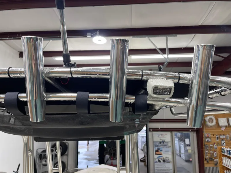 Slide: The Image of 2025 Key West 203FS boat with stainless steel rod holders and LED light in a showroom. - 27