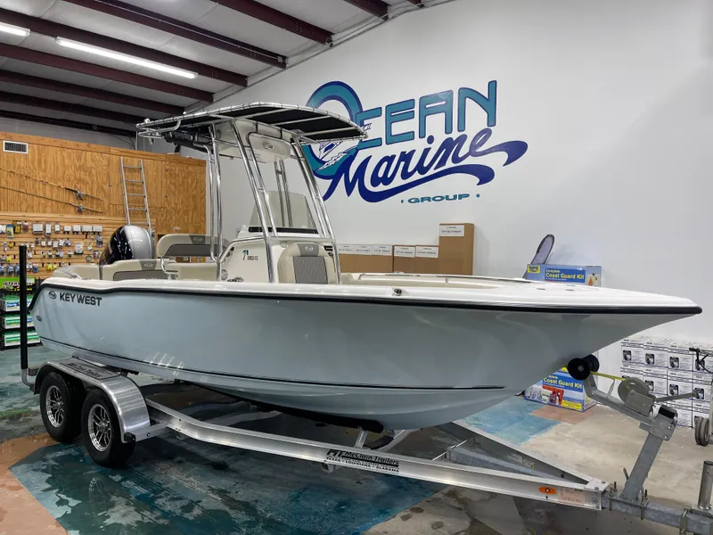 Slide: The Image of 2025 Key West 203FS boat on trailer in showroom, Ocean Marine Group. - 3