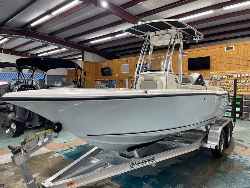 Slide: The Image of 2025 Key West 203FS boat on trailer in showroom, under bright lighting. - 6