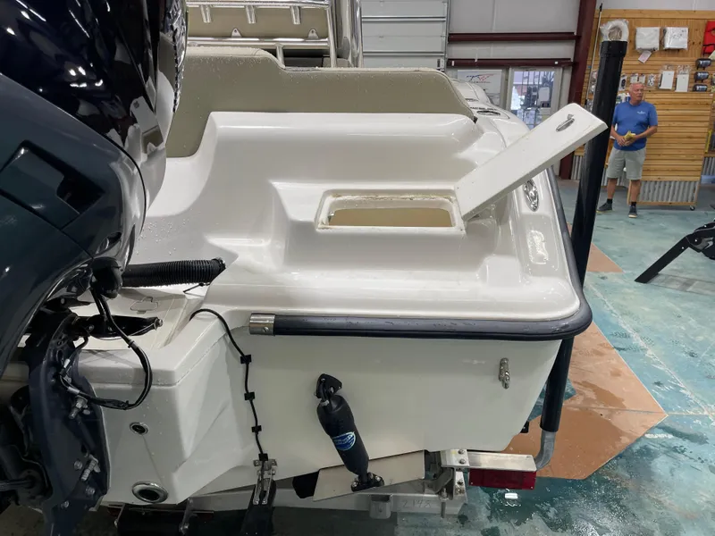 Slide: The Image of 2025 Key West 219fs boat in a workshop, showing rear deck and open compartment. - 10