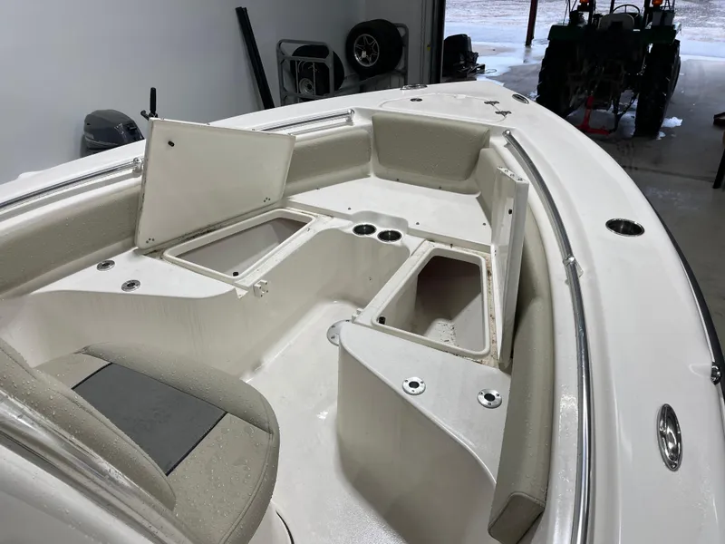 Slide: The Image of 2025 Key West 219fs boat interior with open storage compartments in a garage setting. - 22