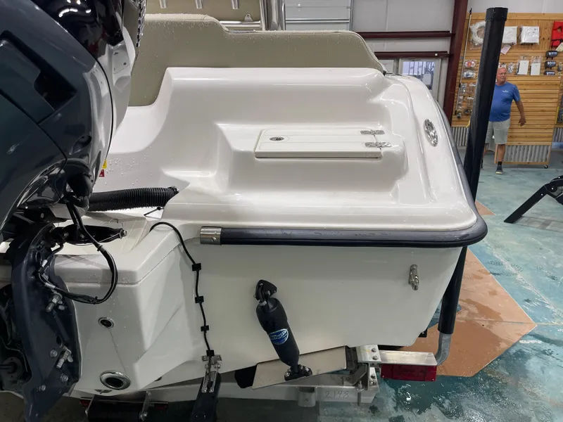 Slide: The Image of 2025 Key West 219fs boat rear view in a showroom, showcasing engine and hull details. - 9