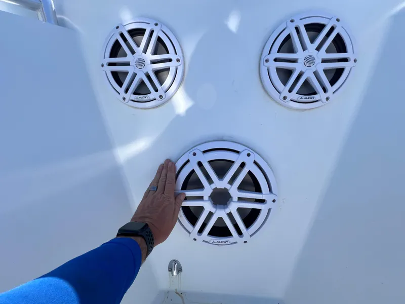 Slide: The Image of Hand touching boat speakers on a 2003 Contender 21 Open with Yamaha engine. - 31