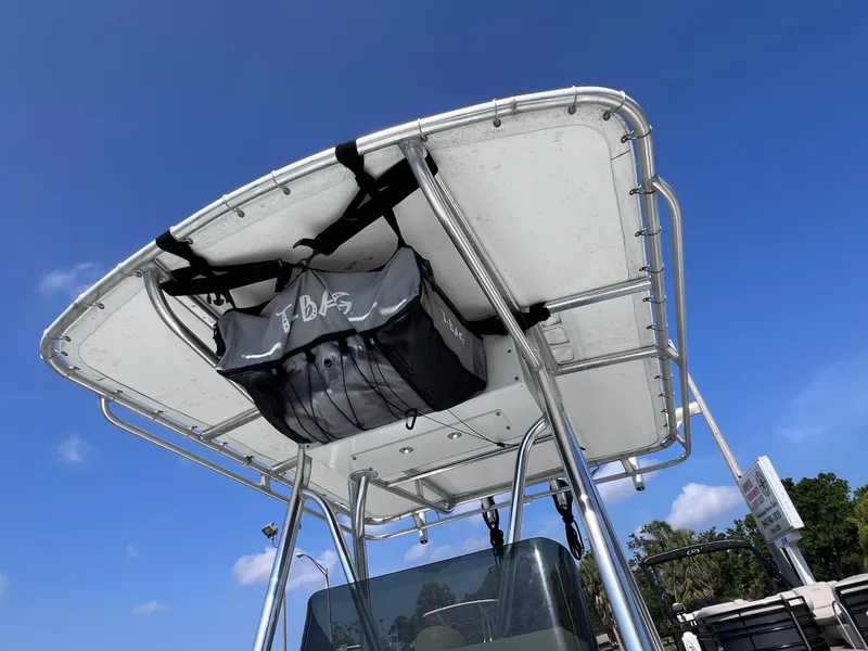 Slide: The Image of T-top of 2003 Contender 21 Open boat with storage bag, clear blue sky background. - 39