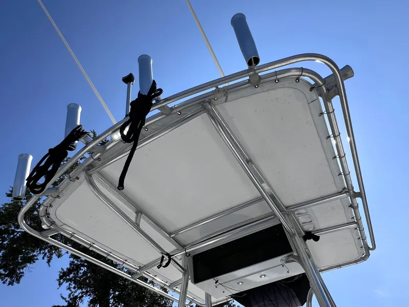 Slide: The Image of T-top of 2003 Contender 21 Open boat with rod holders, clear blue sky background. - 40