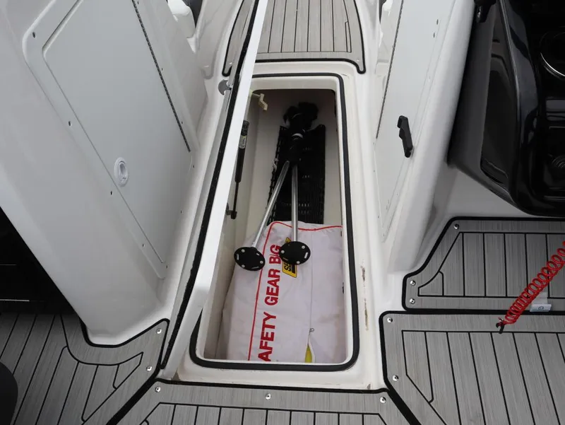 Slide: The Image of Storage compartment on 2021 Yamaha Boats 212, featuring safety gear and equipment. - 17