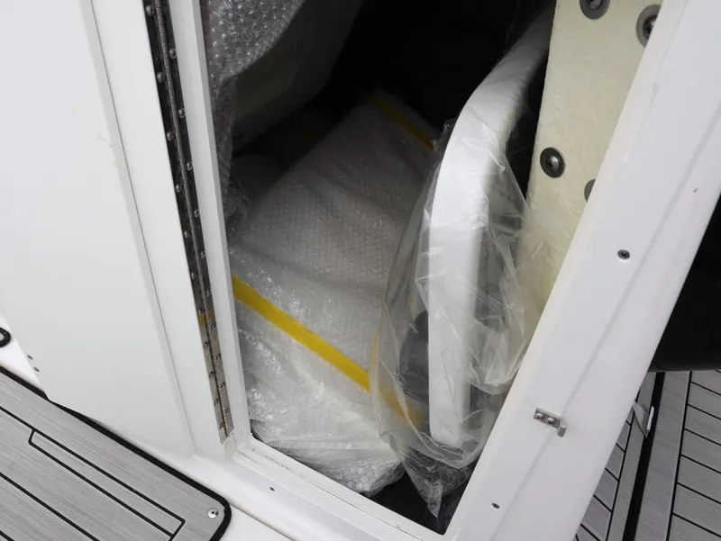 Slide: The Image of Storage compartment of a 2021 Yamaha Boats 212, showing packaged items inside. - 18