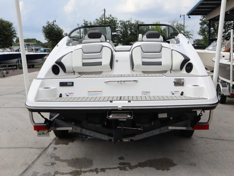 Slide: The Image of 2021 Yamaha Boats 212, rear view, parked on trailer at marina. - 22