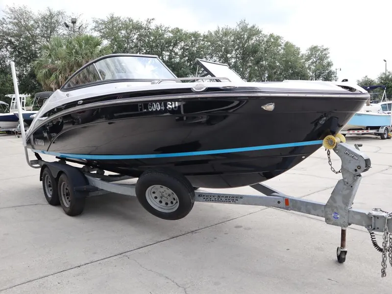Slide: The Image of 2021 Yamaha Boats 212 on trailer, sleek black design, parked outdoors. - 4