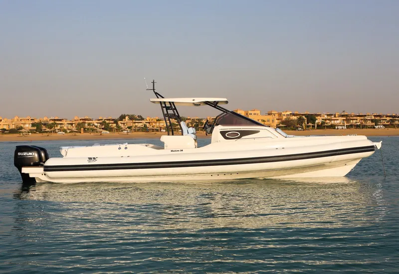 Slide: The Image of 2026 Tiger Marine Maxline 38 boat on calm water, featuring sleek design and Suzuki outboard motor. - 4