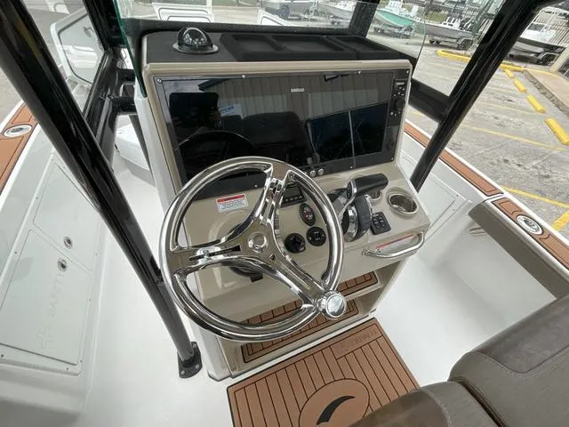 Slide: The Image of 2020 Crevalle 260HCO boat helm with steering wheel and navigation controls. - 11