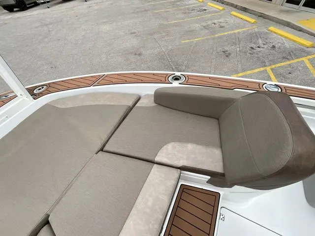 Slide: The Image of 2020 Crevalle 260HCO boat with cushioned seating and wood accents in a parking lot. - 19