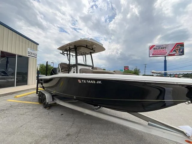 Slide: The Image of 2020 Crevalle 260HCO boat on trailer near service center, cloudy sky background. - 2