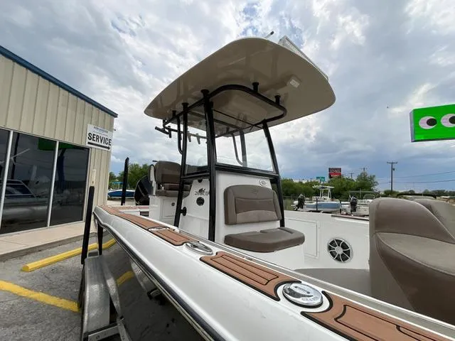 Slide: The Image of 2020 Crevalle 260HCO boat with T-top, docked near service area under cloudy sky. - 24