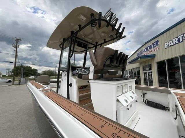 Slide: The Image of 2020 Crevalle 260HCO boat with center console, rod holders, and measuring ruler, parked outside dealership. - 31