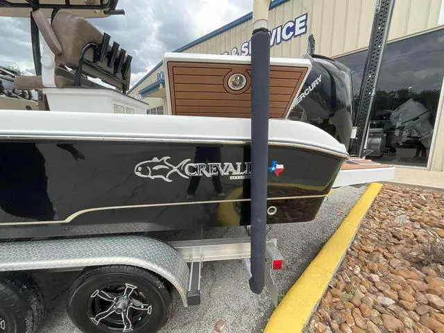 Slide: The Image of 2020 Crevalle 260HCO boat on trailer, black exterior, parked near service building. - 4