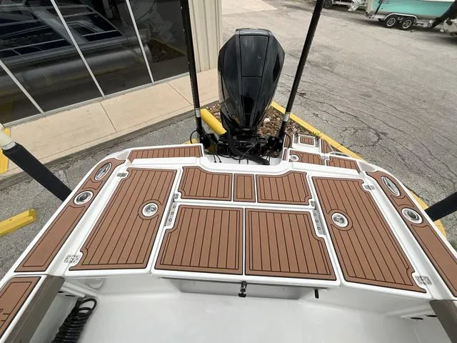Slide: The Image of 2020 Crevalle 260HCO boat with wood-patterned deck and outboard motor. - 7