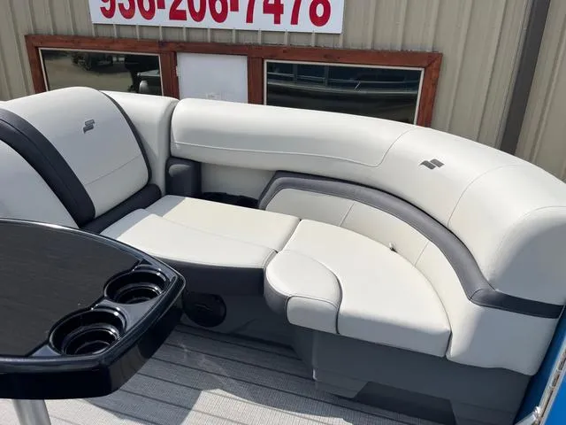 Slide: The Image of 2025 Starcraft EX20QDH boat interior with plush seating and cup holders. - 16