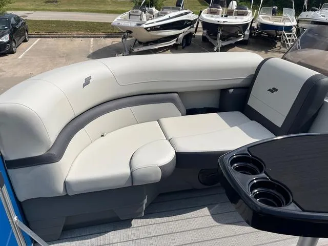 Slide: The Image of 2025 Starcraft EX20QDH boat interior with plush seating and cup holders. - 17