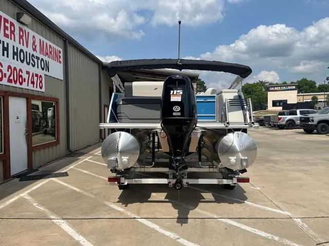 Slide: The Image of 2025 Starcraft EX20QDH pontoon boat with 115 HP engine at dealership parking lot. - 7