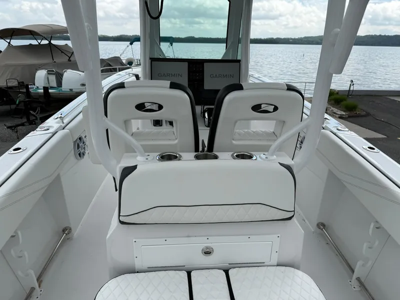 Slide: The Image of 2025 Stingray 273 CC boat interior with white seating and dual Garmin displays. - 10