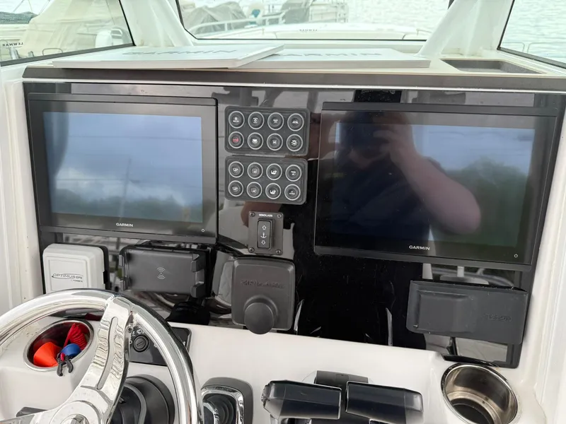 Slide: The Image of 2025 Stingray 273 CC dashboard with dual Garmin displays and control panel. - 13